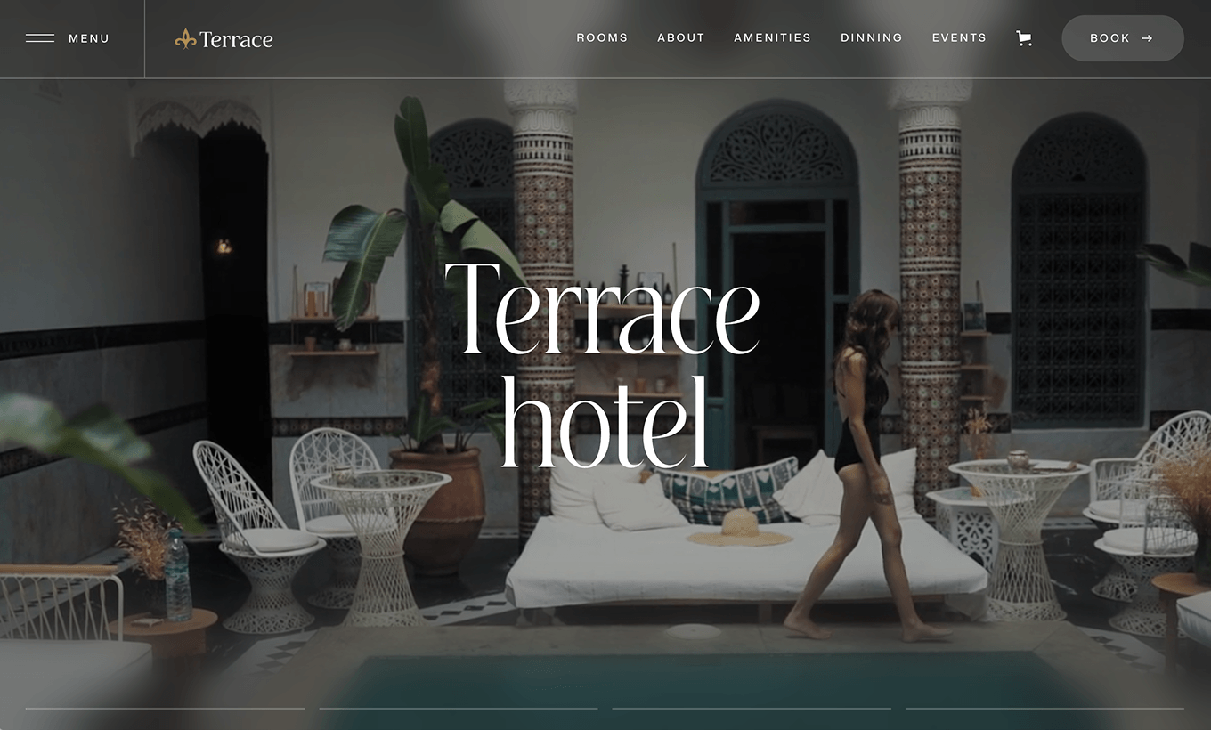 Woman in black swimsuit walking by a pool in a stylish terrace hotel courtyard with white furniture.
